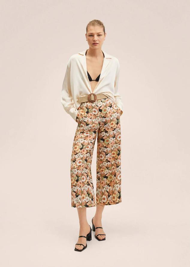 Pantalón culotte en tejido fluido con estampado floral, bolsillos laterales, tiro alto, cintura elástica y detalle de cinturón con hebilla, de Mango. Cómpralo con descuento por 19,99 euros.