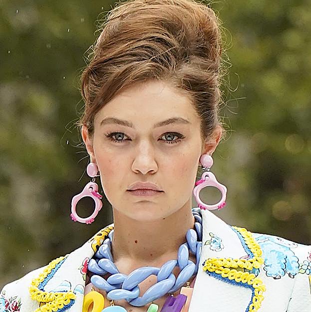 Imagen principal - Para conseguir el moño con volumen de Gigi Hadid prueba con el champú Original Remedies Oliva Mítica (3,30 €) y laca Elnett Satin de L'Oréal Paris (5,50 €).