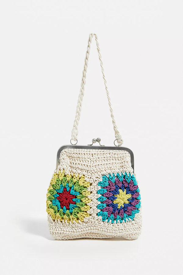 Con una estética de inspiración boho en este bonito bolso, tiene una fabricación textil de punto. Cuenta con una sujeción de clip, una sola correa para el hombro y un diseño inspirado en el ganchillo de colores brillantes a un lado. Es de Urban Outfitters. Precio: rebajado: 35 €.
