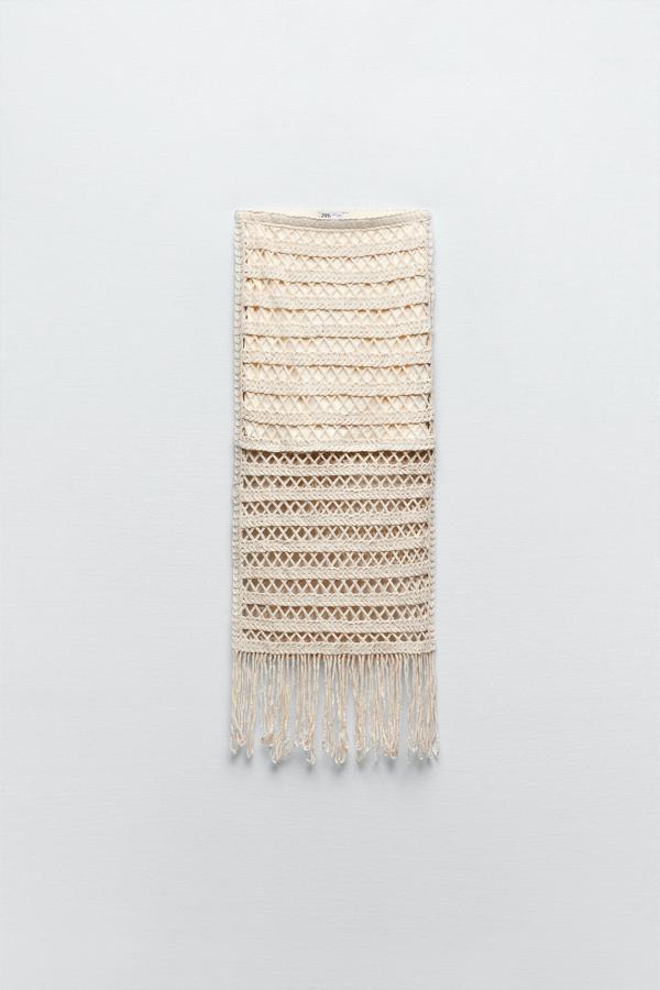 Estilo midi de tiro alto con cintura elástica, posee un forro interior combinado a tono. Además, el bajo está acabado en flecos de color crudo. De Zara. Precio rebajado: 15,99