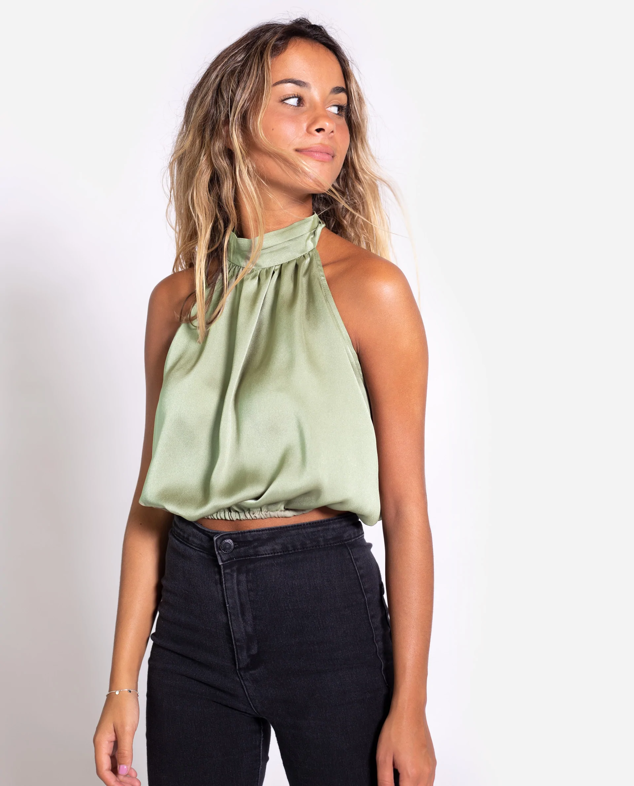 Top verde de tirantes elegante, tiene escote halter con cuello alto que estiliza y hace parecer más alta. El tejido es ligero y suave, además la espalda queda completamente descubierta y el efecto ablusado es súper favorecedor. Es de The Are. Precio: 42,95 €.