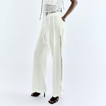 Imagen secundaria 1 - No puede falta en ningún armario estival un pantalón blanco que haga tipazo. Pantalones anchos de lino de color blanco con detalles laterales de una banda con entredós bordados al mismo tono de Zara (35,99 euros) 
