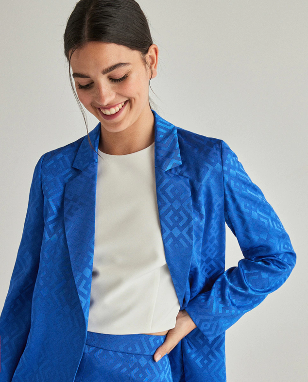 Con estampado geométrico y confeccionada en un azul vibrante. Esta blazer es idónea para lucirla con tops o camisetas blancos. Es de Grean Coast. Precio: 49,99 €.