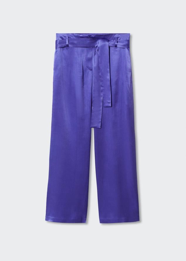 Pantalón de tejido fluido y satinado disponible en los colores morado y fucsia. Se cierra mediante un lazo que puedes usar como cinturón para acentuar la cintura. Es de Mango. Precio: 39,99 €.