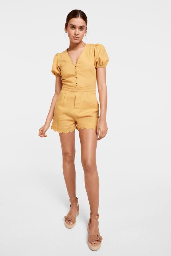 Mono corto en tejido de lino con escote de pico, cierre de botones a tono, manga corta abullonada y bajo festoneado, color dorado, de Springfield. Cuesta 12,99 euros rebajado.