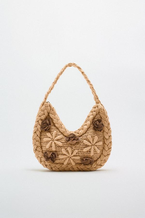 Si todavía no has encontrado el bolso de rafia perfecto, aquí lo tienes. Un diseño especial, cubierto con bordados en forma de flor, que te acompañará en todos tus planes veraniegos. Bolso de rafia de Zara (39,99 euros). 