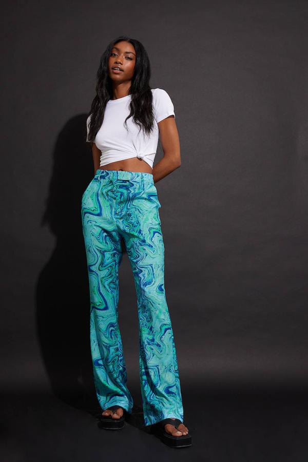 Pantalón largo de diseño flared con tiro alto y estampado abstracto, en verde, de NA-KD. Los encontrarás rebajados a 34,97 euros. Cómpralo aquí