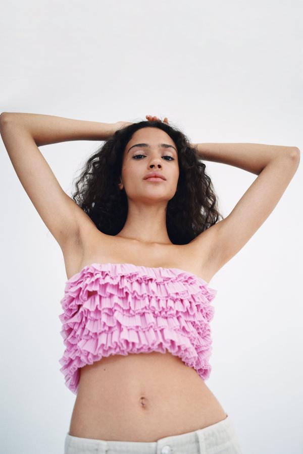 Top bandeau con escote recto y confeccionado en organza para crear un acabado con volumen. Su color rosa sigue la tendencia de Barbiecore. Es de Zara. Precio: 19,95 €.