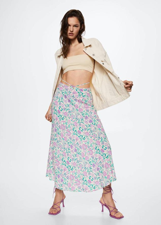 Falda midi fluida con diseño evasé, tiras decorativas y estampado floral en crudo, morado y verde, de Mango. Tiene un coste de 25,99 euros.
