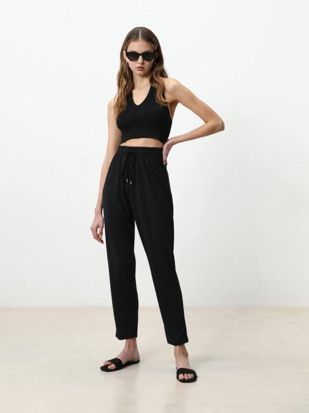 Pantalón fluido de tiro alto con cintura elástica ajustable mediante cordones. Lo encontrarás a 6,99 euros, en 9 colores y estampados diferentes.