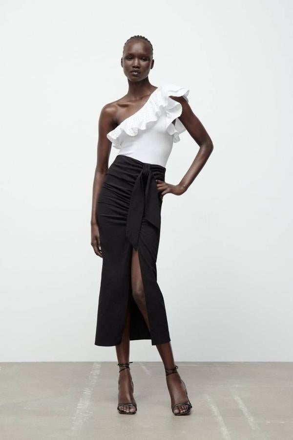 Body asimétrico con silueta ajustada, manga sisa y detalle de volantes a tono con volumen y tejido bordado y perforado, color blanco. Puedes encontrarlo a 19,95 euros