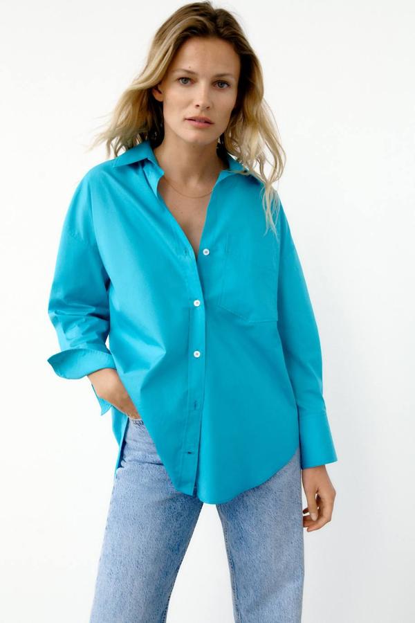 Camisa básica en tejido de popelín con corte amplio, manga larga y cuello solapa, de Zara. Tiene un precio rebajado de 12,99 euros.