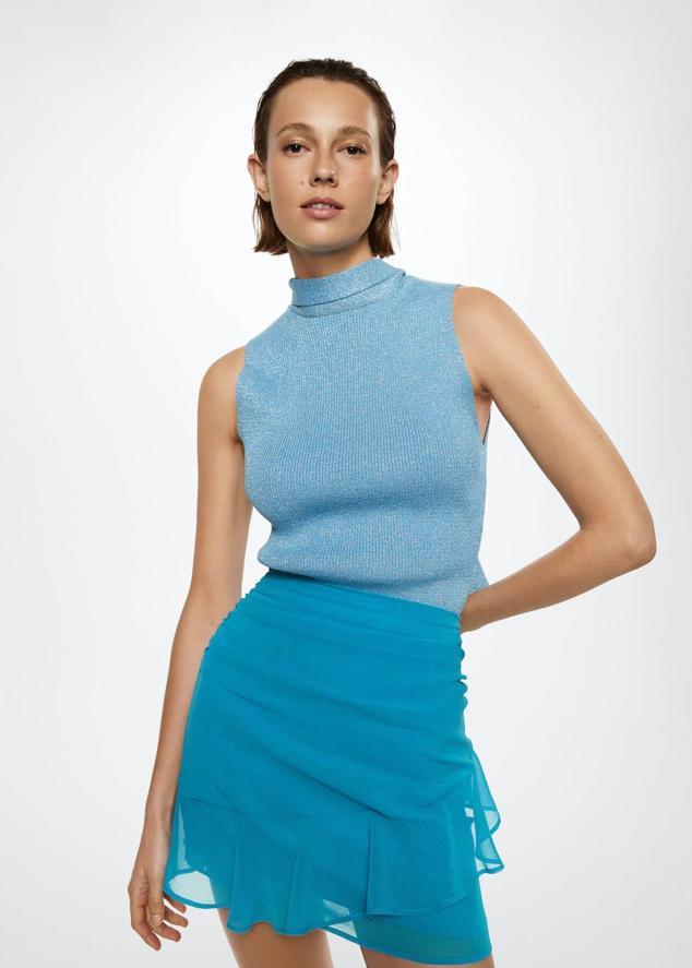 Falda corta en tejido ligero vaporoso con detalles drapeados, volante y tiro alto, de Mango. La encontrarás a 29,99 euros.