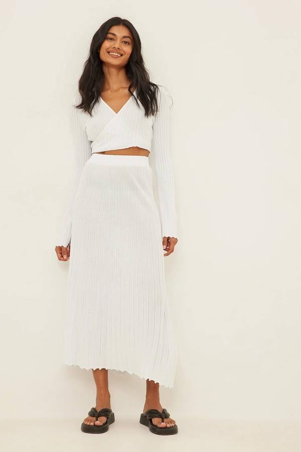 Falda midi vaporosa de punto fino acanalado con diseño amplio y tiro alto, color blanco, de NA-KD. La encontrarás por 63,95 euros.