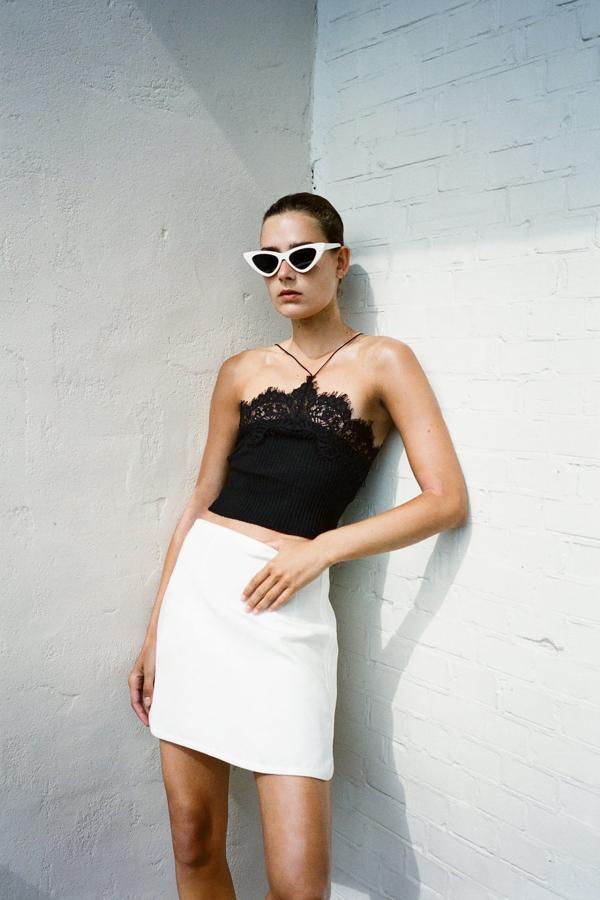 El escote halter es perfecto para lucir hombros bronceados. El color negro se alía con el blanco para formar el binomio más elegante. Top con encaje de Zara (12,99 euros). 