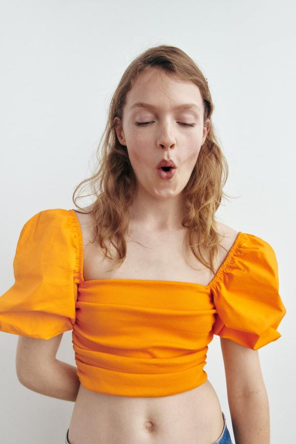 Un top sencillo, pero con una dosis extra de volumen en las mangas. Top drapeado en color naranja de Zara (15,99 euros). 
