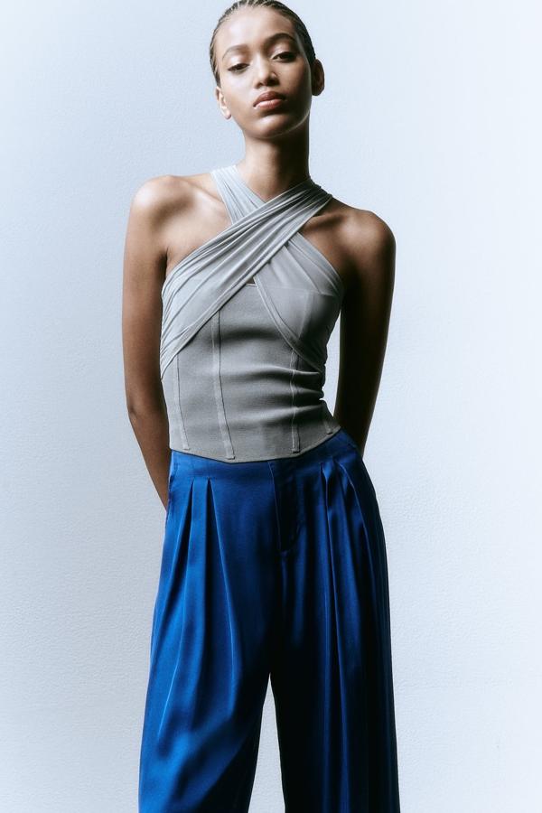 El escote halter se posiciona como uno de los más deseados para las noches de verano. El gris es el tono comodín. Top drapeado de Zara (25,99 euros). 