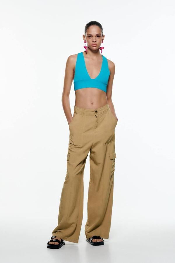 Pantalón wide leg cargo con tiro alto, bolsillos de plastrón en los laterales y la pernera, falsos bolsillos de vivo en la espalda y trabillas para el cinturón, color camel medio, de Zara. Cuesta 12,99 euros rebajado.