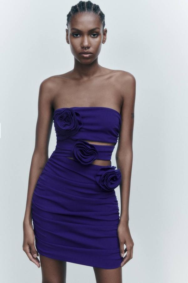 Vestido corto ajustado con escote recto, hombros al descubierto, diseño con aberturas en la parte frontal y detalle de flores en relieve, color azulón. Cuesta 39,95 euros.