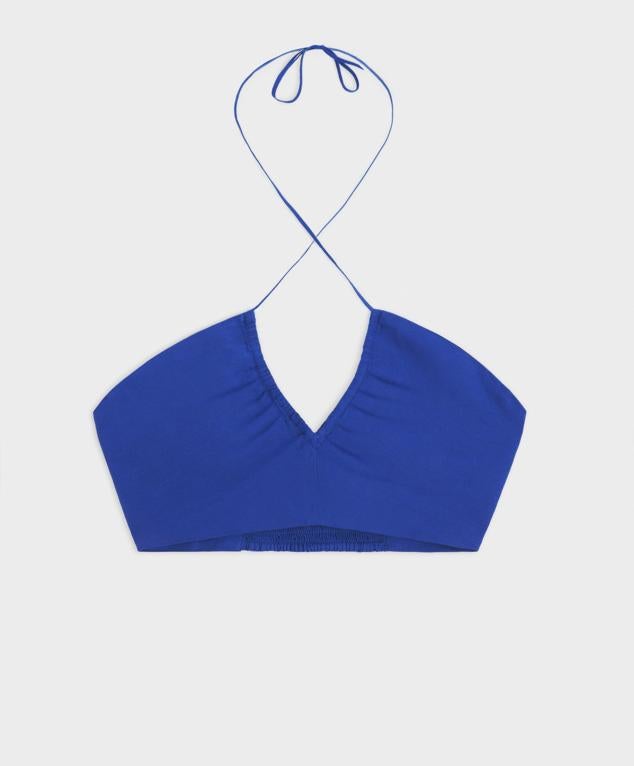 Tops de tirantes cruzados diseñado en lino. Ideal para cualquier día con temperaturas demasiados altas, conseguirás un look fresquito al instante. Es de Oysho. Precio: 19,99 €.