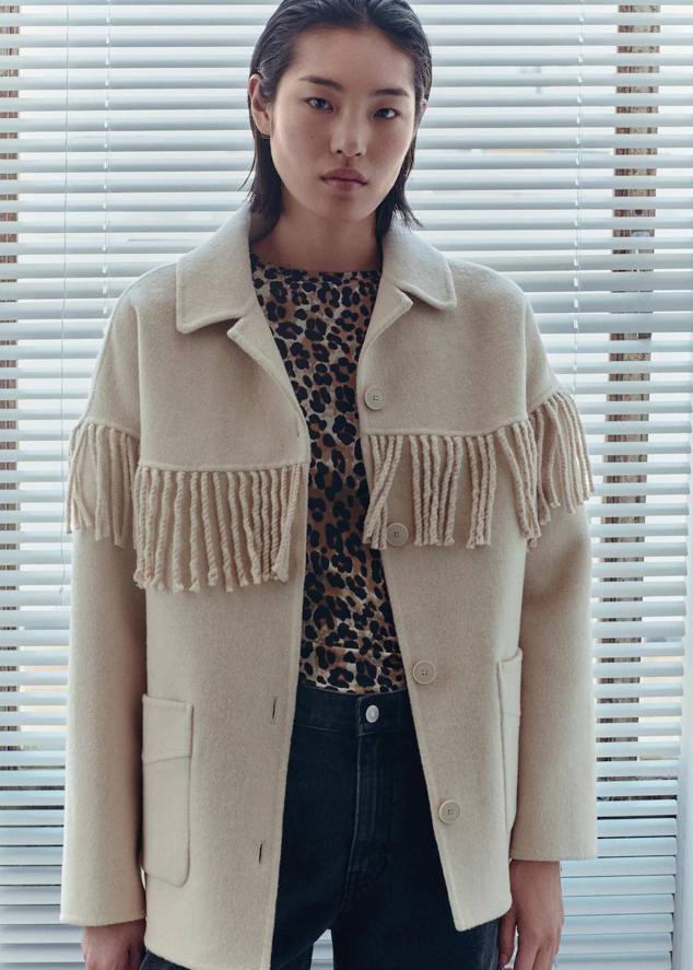 Chaqueta de lana oversize con diseño handmade, cuello solapa, bolsillos de plastrón, cierre de botones a tono detalle de flecos, en crudo. Cómprala a 149,95 euros.