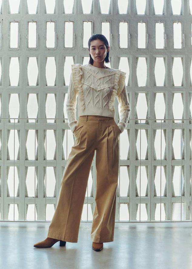 Pantalón largo de vestir en tejido de algodón con pernera ancha tipo wide leg, detalle de pinzas y raya marcada, bolsillos laterales y trabillas para el cinturón, en arena. Puedes encontrarlos a 39,99 euros.