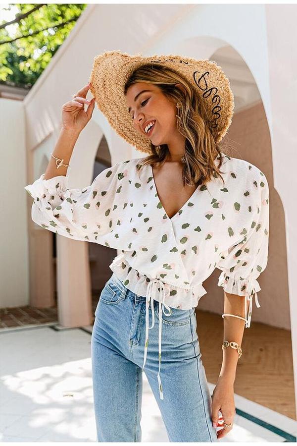 Blusa blanca boho con estampado de color caqui y rosa. Diseñada en estilo wrap para afinar la cintura y la zona del pecho. Es de Amor Bohemio. Precio: 23,99 €.