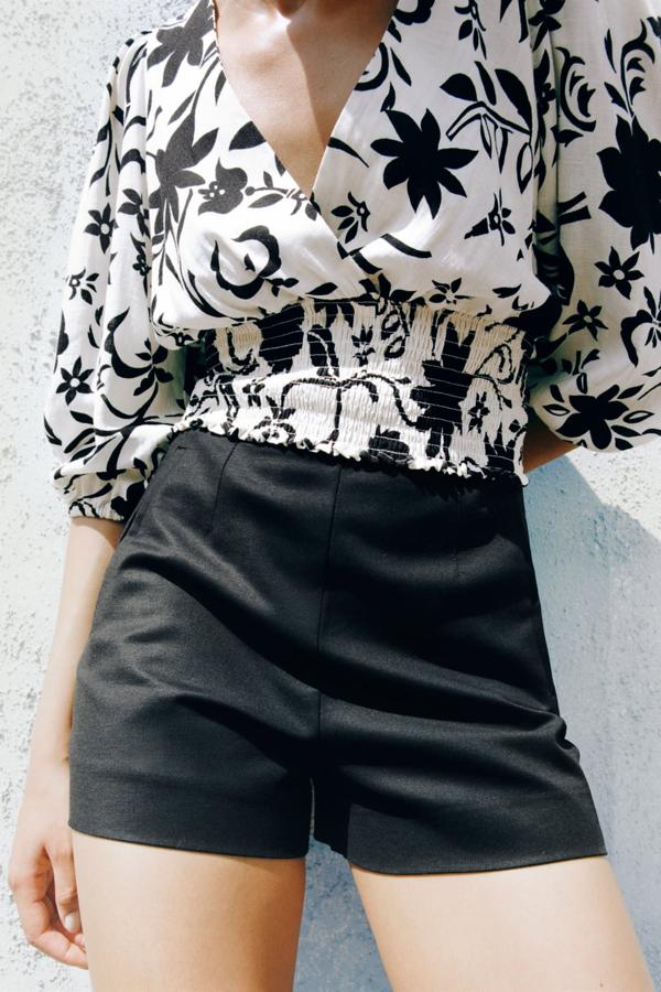 En tejido ligeramente satinado, en color negro, de tiro alto y extra cortos. Shorts negros de tiro alto de Zara (22,99 euros). 