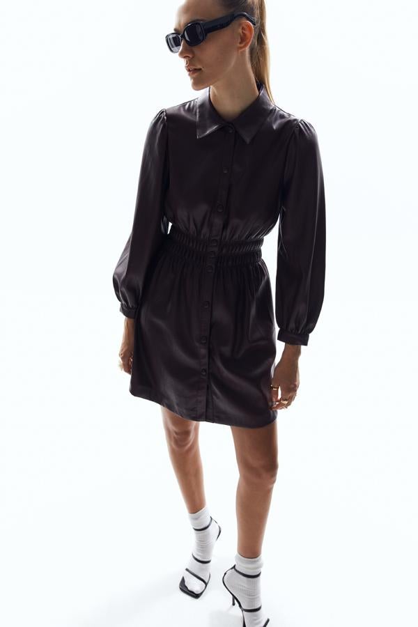 Vestido corto de cuello solapa y manga larga acabada en puño. Detalle de fruncido en la cintura para aportar ese efecto estilizador que tanto favorece. Disponible en dos colores: vino y negro. Precio: 39,99 euros.