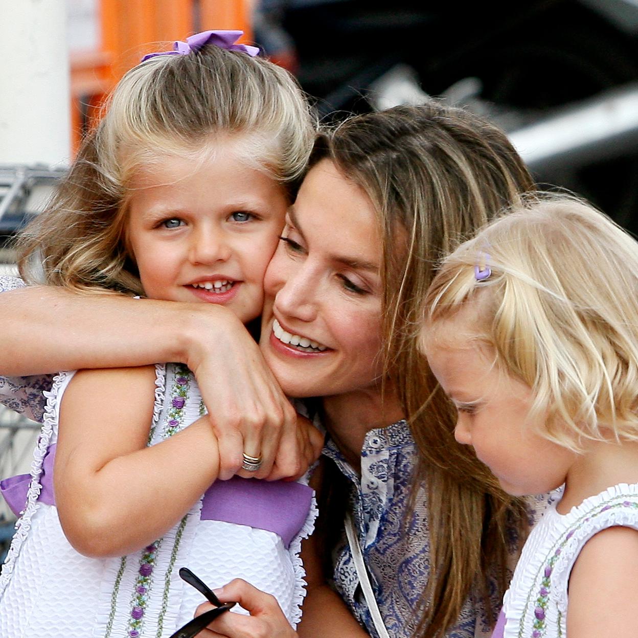 La reina Letizia abraza a la princesa Leonor junto a la infanta Sofía, en Palma de Mallorca en 2009.