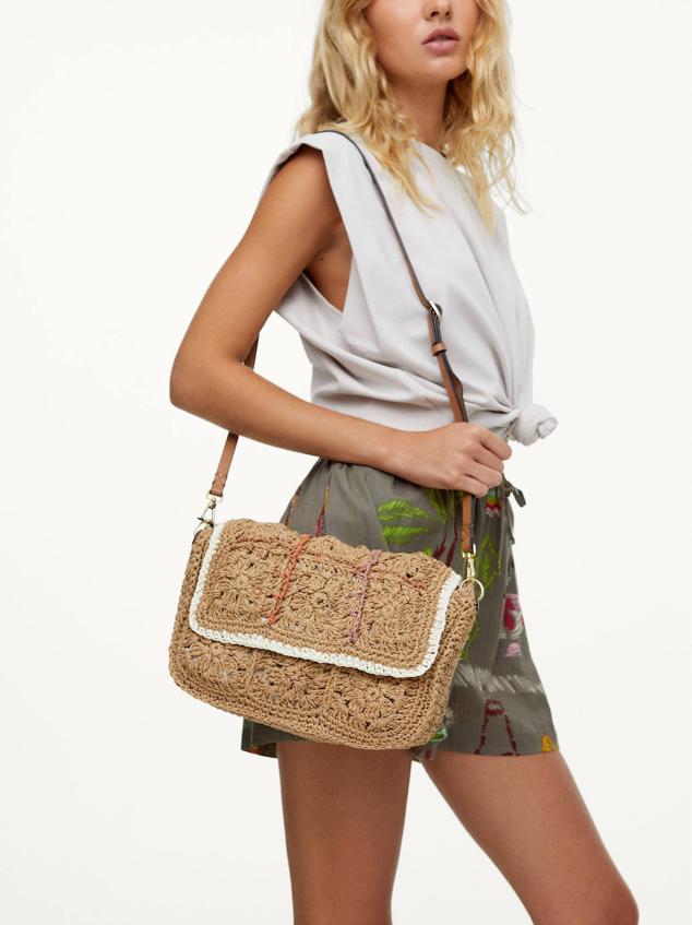 Bolso bandolera en tejido trenzado con cierre de solapa por imán, forro de lino y bolsillo interior, en tono natural. Cuesta 22,99 euros.