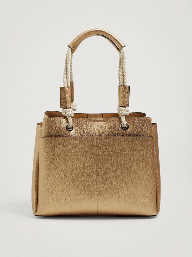 Shopper efecto piel con acabado metalizado dorado, doble asa de hombro en tejido trenzado con nudos, bolsillos exteriores delanteros y cierre de imán. También lo puedes comprar en negro, camel, azul marino y crudo, a 22,99 euros.