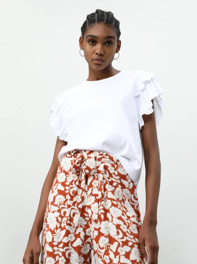 Camiseta en tejido 100% algodón con cuello redondo y manga corta con volantes decorativos, de Lefties. Está disponible en blanco, negro, rosa y verde oscuro, por 5,99 euros.