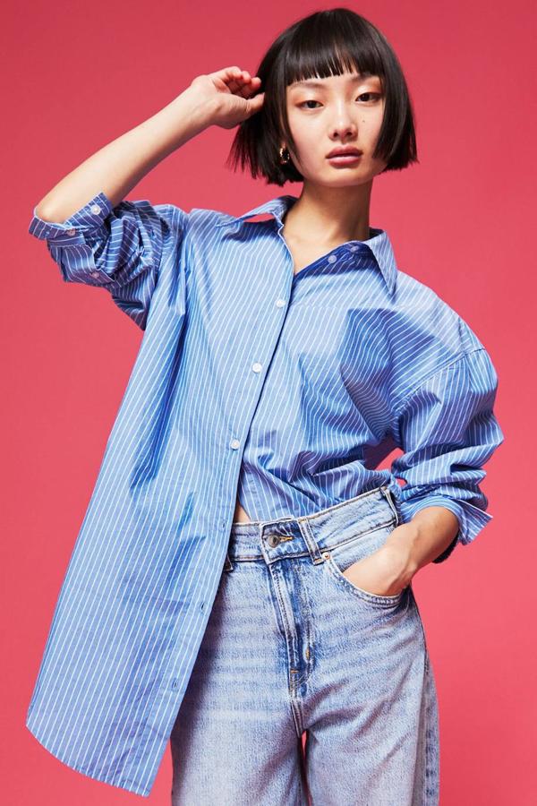 Camisa en tejido de algodón con corte holgado, cuello solapa, manga larga, cierre de botones y bajo redondeado, en estampado de rayas finas azul y blanco. Cuesta 19,99 euros.