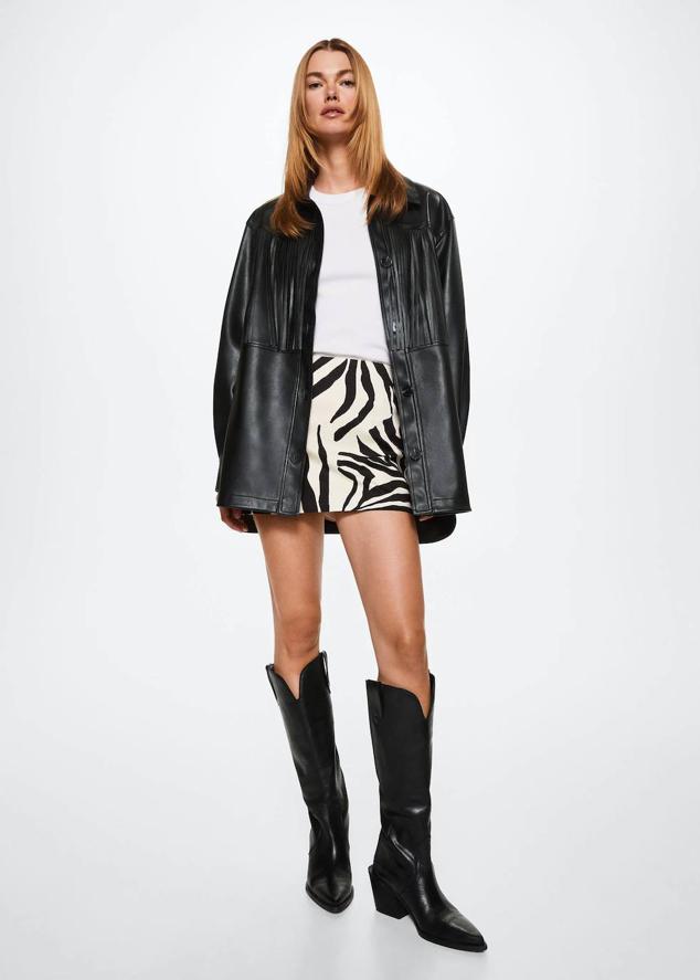 Chaqueta oversize efecto piel con cuello camisero, manga larga, detalle de flecos y cierre frontal de botones a tono, color negro, de Mango. Su precio es de 69,99 euros.