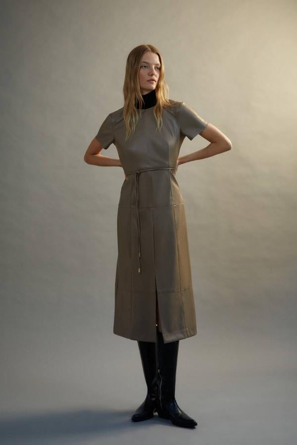Vestido midi efecto piel con cuello redondo, manga corta, detalle de cinturón de lazada a juego y abertura en el bajo, de Sfera. Lo encontrarás en tonos taupe, verde oscuro o negro, con un coste de 39,99 euros.