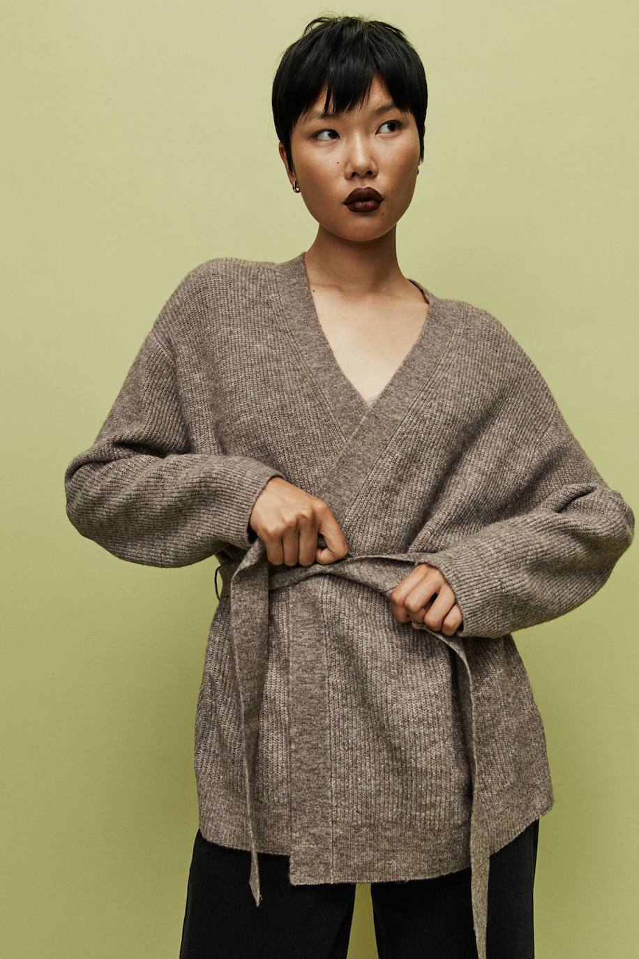 Cárdigan en tejido de punto con diseño abierto, escote de pico, manga larga, silueta relajada y cinturón a juego de lazada, color topo oscuro, de H&M. Cómpralo por 24,99 euros.