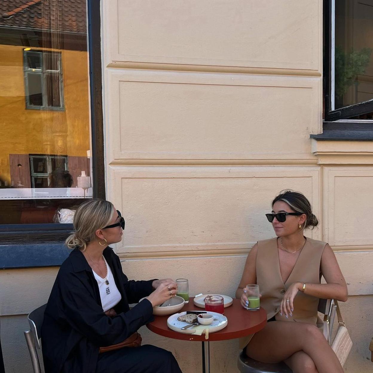 Las influencers Elise Marielouise y Benthe Liem tomando café en una cafetería.