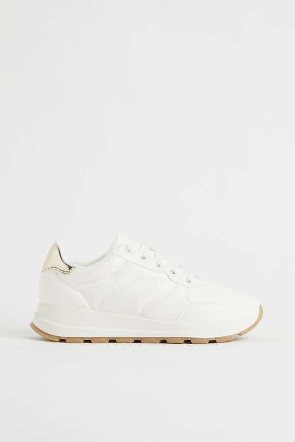 Zapatillas deportivas clásicas en piel sintética con cierre de cordones y refuerzo en el talón con acabado metalizado, color blanco, de H&M. Cuestan 29,99 euros.