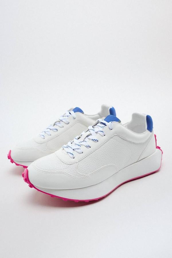 Zapatillas deportivas estilo running con cierre de cordones, suela con tacos y detalles a contraste en blanco, azul y rosa, de Zara. Tiene un precio de 39,95 euros.