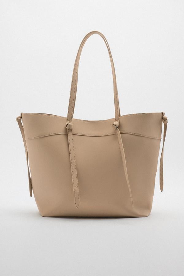 Los bolsos son el accesorio perfecto para estrenar la nueva temporada. Y los de diseño shopping bag son perfectos para la vuelta a la oficina. Bolso en color arena de Zara (22,99 euros). 
