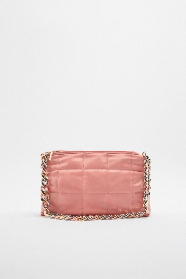 Los tonos pastel también son para el otoño. Bolso acolchado en color rosa con cadena dorada de Zara (25,99 euros). 
