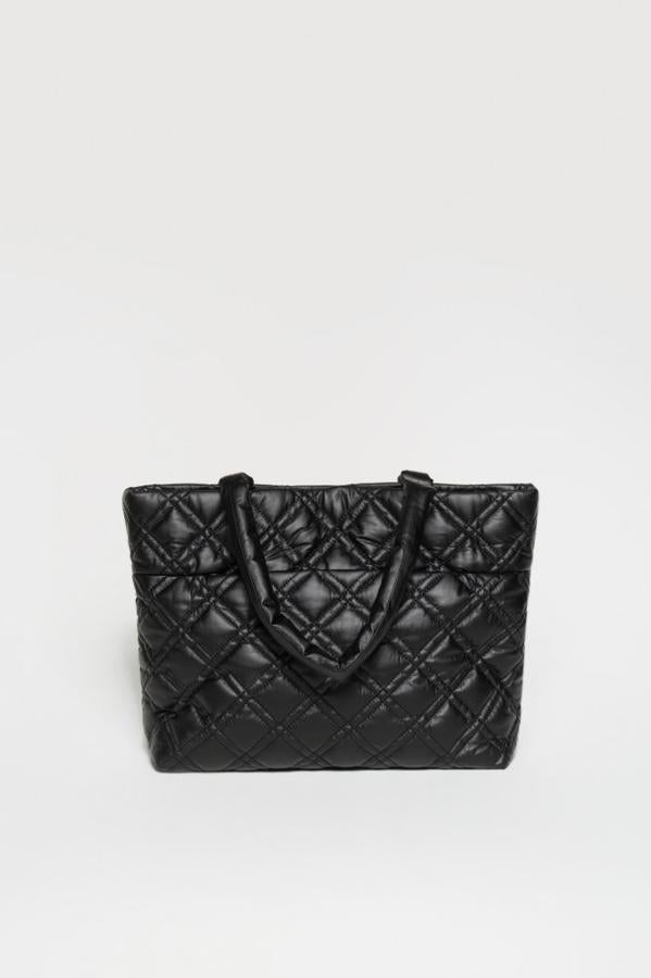 Un diseño inspirado en los míticos bolsos e Chanel que podrás llevar sin parar en tu día a día. Bolso acolchado de color negro de Sfera (19,99 euros). 