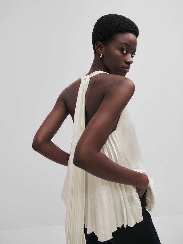 Top plisado con corte fluido, cuello halter con lazada y escote de pico, color blanco, de Massimo Dutti. Cómpralo por 89,95 euros.