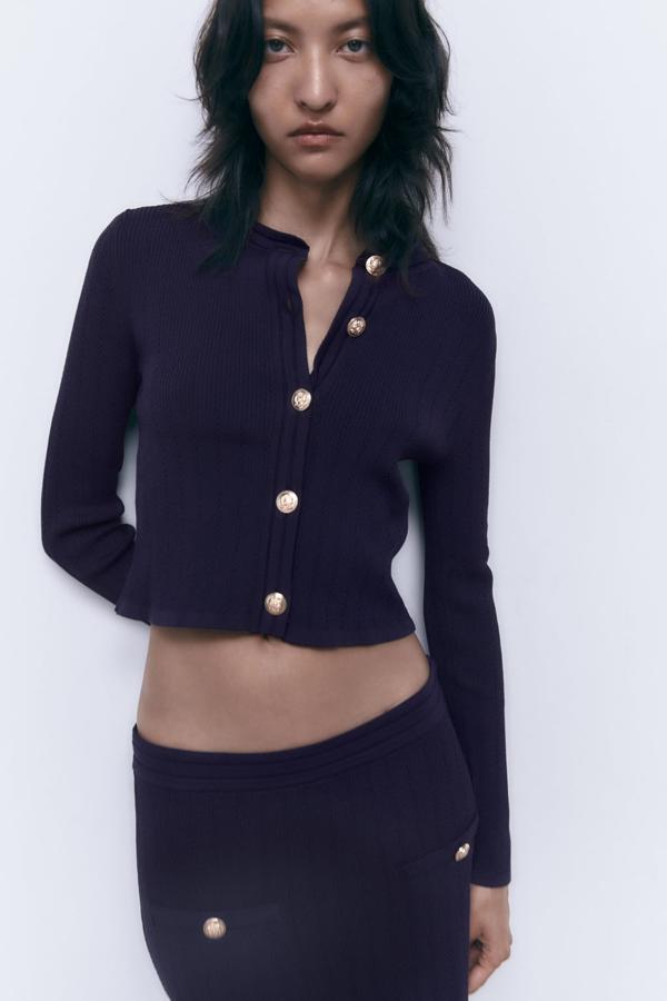 Las prendas de punto empiezan a colarse en los armarios de entretiempo. Chaqueta de punto con botones dorados de Zara (29,99 euros): 