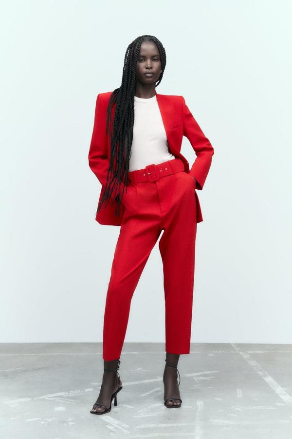 Si quieres poner una nota de color a los trajes de oficina, el rojo será tu mejor aliado. Pantalón con cinturón de Zara (29,99 euros). 