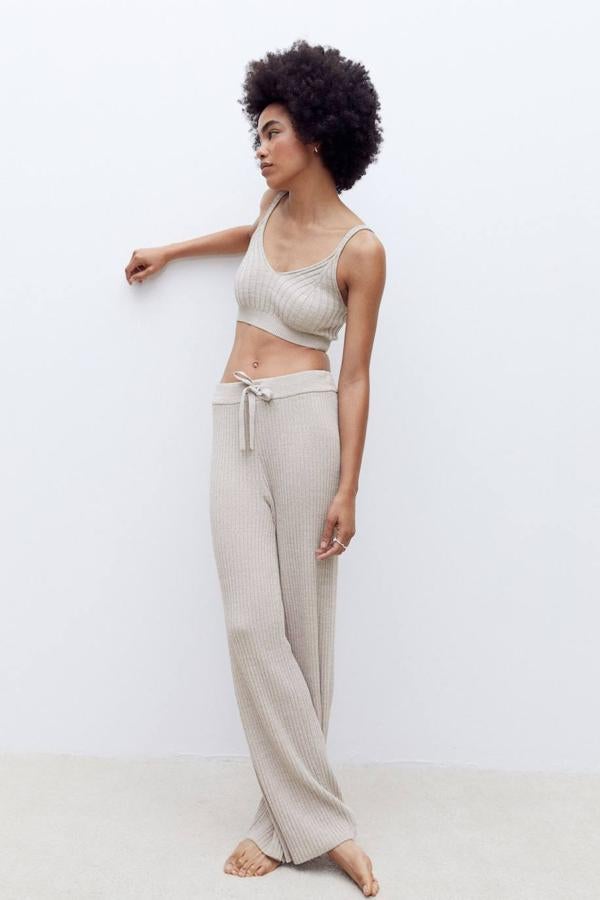 Pantalón largo en tejido de punto fino de canalé con tiro alto, cintura elástica ajustable mediante cordones y perneras anchas, tono topo claro, de H&M. Su precio es de 24,99 euros.