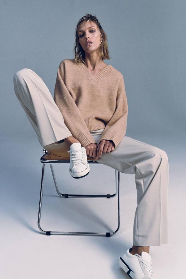 Jersey en tejido de punto soft con silueta relajada, manca larga y cuello de pico, en tono tostado, de Zara. Lo encontrarás a 27,95 euros.