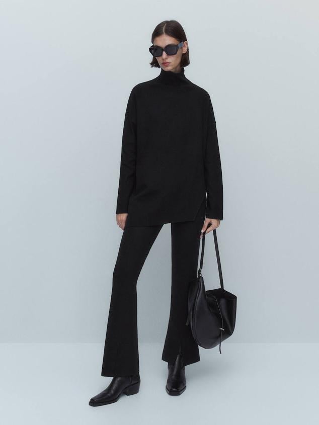 Pantalón de punto con tiro alto, cintura elástica, pernera ajustada y bajo acampanado con abertura, en negro, de Massimo Dutti. Tiene un precio de 59,95 euros.