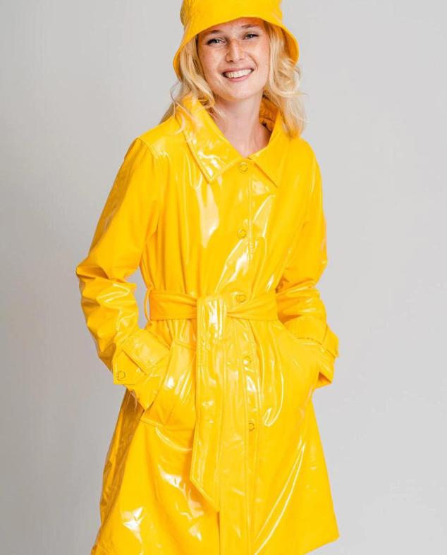 Abrigo impermeable acharolado disponible en tres colores: amarillo, rojo y azul. Incluye cinturón y tiene bolsillos delanteros. Precio: 125 euros en El Corte Inglés. Cómpralo aquí